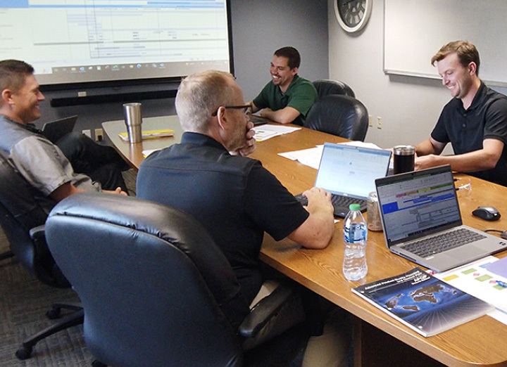 4 men in a conference room discussing Link products