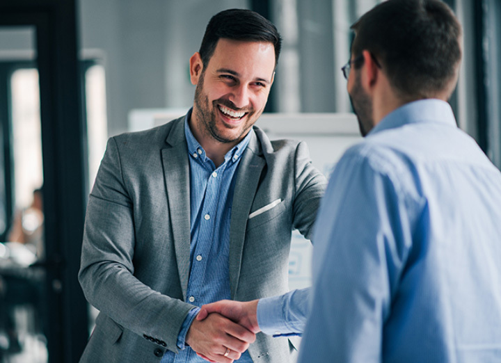 Two men shaking hands and smiling