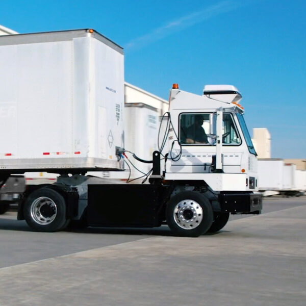 A terminal tractor pulling out of a dock with a trailer