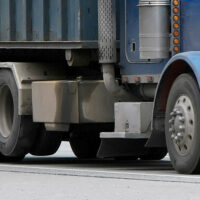 Tires on a dump truck, including a lifted non-steerable auxiliary suspension