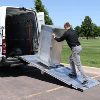 Man pushing a refrigerated unit up the LB20 ramp into a cargo van.