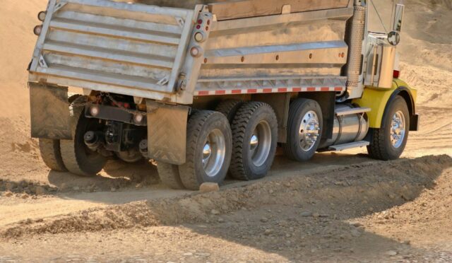 A dump truck being loaded with dirt