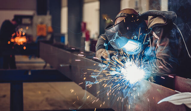 A man welding at Link Suspensions of Canada