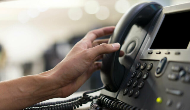 A hand reaching to answer a phone